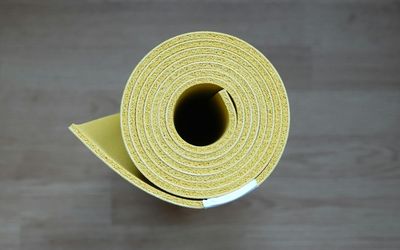 A yoga mat rolled out on a wooden floor.